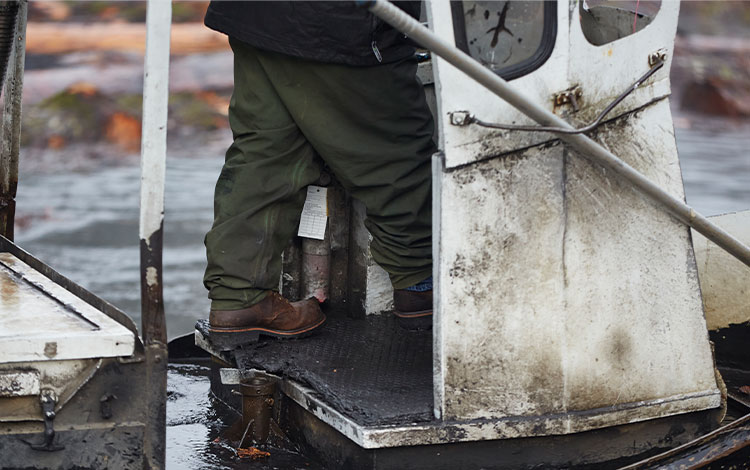 A man on a boot wearing Chippewa boots in brown.